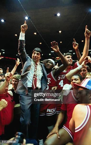 Albuquerque, New Mexico: North Carolina State's coach Jim Valvano gives the winning sign as he stand with his winning team at the NCAA Final Four...