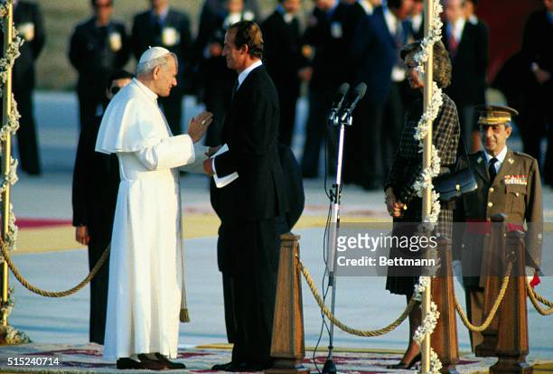 King Juan Carlos and Queen Sofia of Spain welcome Pope John Paul II upon his arrival. | Location: Madrid, Spain.