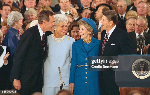 President and Nancy Reagan laugh with Vice President and Barbara Bush during inaugural ceremonies at the Capitol.