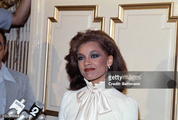 Musically-talented Vanessa Williams, Miss America of 1983, at a press conference, ca. 1982, wearing a white high-necked blouse with bow.
