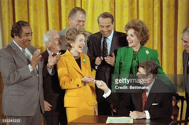 Washington: President Reagan hands his wife, First Lady Nancy Reagan, the pen he used to sign a $1.7 billion anti-drug bill at the White House....