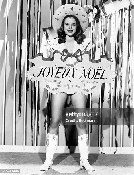 London, England- Diana Dors, British film player, holds an early Christmas greeting in French. The costume doesn't look very wintery.