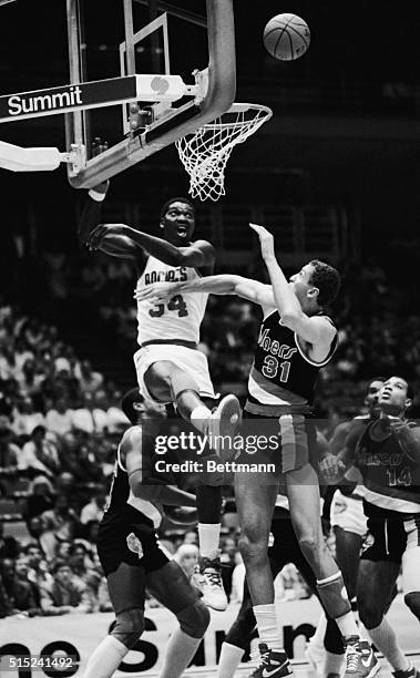 Hakeem Olajuwon of the Houston Rockets battles Sam Bowie of the Portland Trailblazers for the rebound during a basketball game in Houston, Texas.