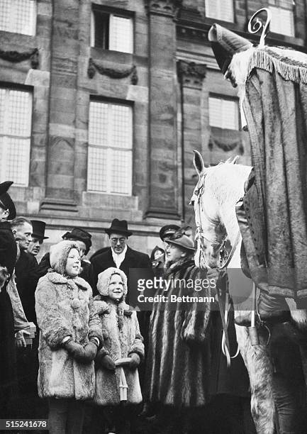 Santa Claus And The Princesses. Amsterdam: Princess Beatrix and Princess Irene of the Netherlands shyly look up at Santa Claus, biding a white horse,...