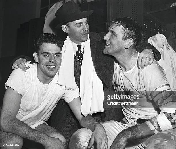 Jubilant Cleveland Browns coach Paul Brown embraces two star players in the Yankee Stadium dressing room Dec. 14th after the Browns defeated the New...