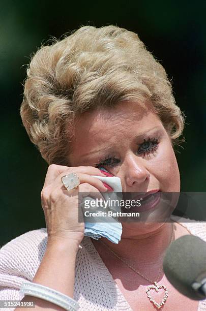 Tammy Faye Bakker wipes a tear from her eye as she speaks with news media outside of her home 6/17. Bakker said she and husband, Jim, would fight for...