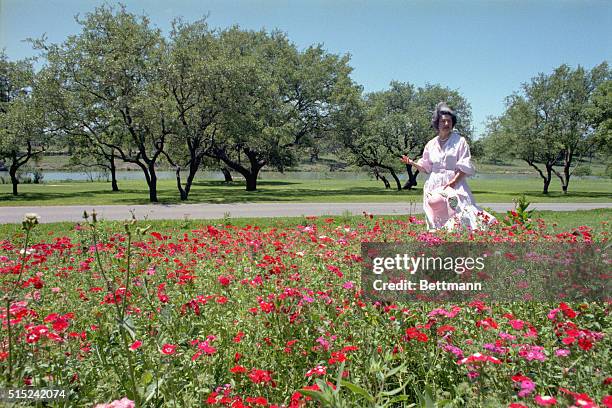 Lady Bird Johnson walks and sits among her wildflower garden at the LBJ Ranch.