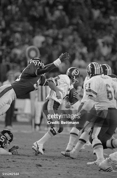 Giant's Lawrence Taylor leaps for Redskin's quarterback Joe Theismann in the second quarter in this photo. Theismann was taken to a local hospital...