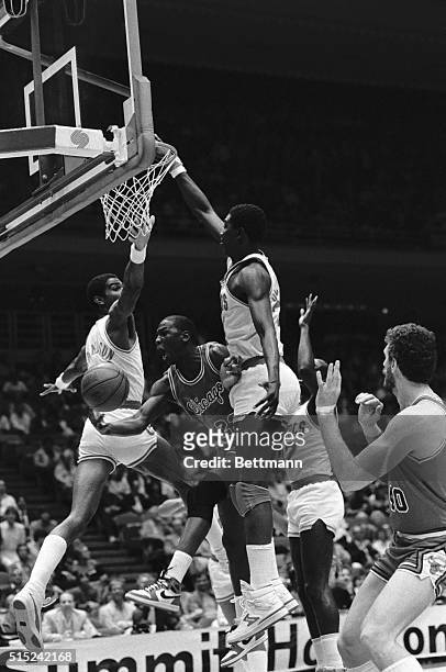 Chicago guard Michael Jordan threads the needle between Houston's Twin Towers, Akeem Olajuwon and Ralph Sampson, trying to lay the ball up towards...