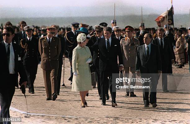 President Reagan places his hand on Queen Elizabeth's shoulder-those behind smile, Olav of Norway salutes. Left to right: Prince Philip, Baudovin of...