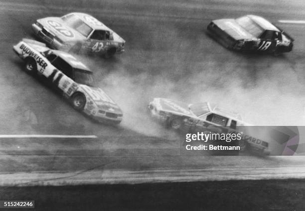 Richard Petty of Randleman, North Carolina and Tommy Ellis of Richmond, Virginia speed by as Darrell Waltrip of Franklin, Tennessee and Rusty Wallace...