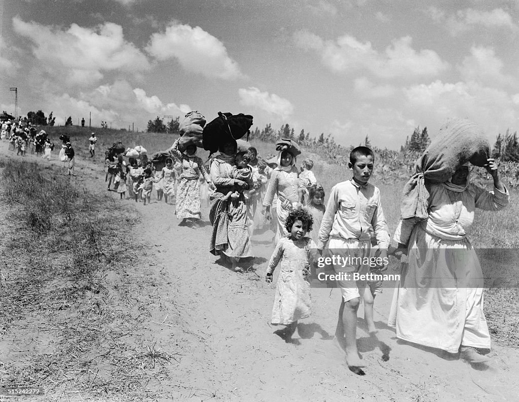 Women and Children Carrying Their Possessions