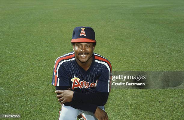 Smiling California Angels' pitcher Bonnie Moore kneels down in the outfield, folding his arms across his chest.