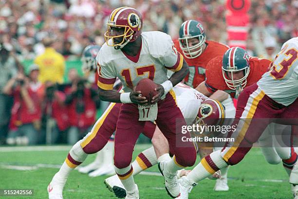 San Diego: Doug Williams readies to take the snap from center then spins to hand off during Super Bowl action.