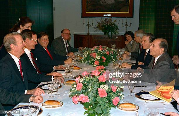 Tokyo: U. S. President George Bush and Secretary of State James Baker share a laugh across their luncheon table with French President Francois...