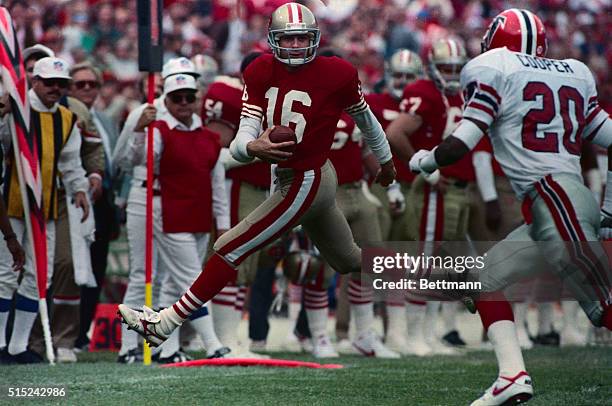 San Francisco 49ers' quarterback Joe Montana runs for a first down with Atlanta Falcons' Evan Cooper in persuit.