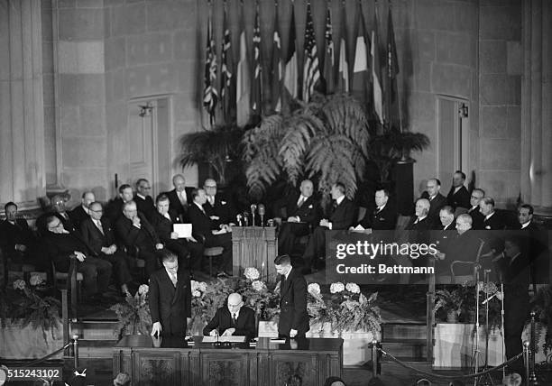 Washington, DC- French Foreign Minister Robert Schuman signs the North Atlantic Treaty. At the table in foreground are : France's Ambassador to the...