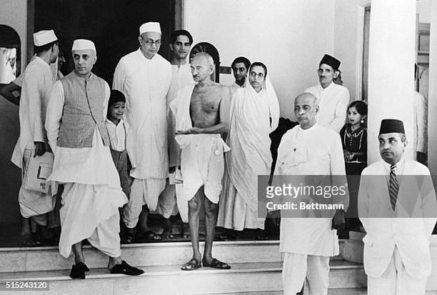 Mahatma Mohandas K. Gandhi, Indian political and spiritual leader, outside of his new residence, "Birla House," in Bombay. Accompanying Mahatma is...