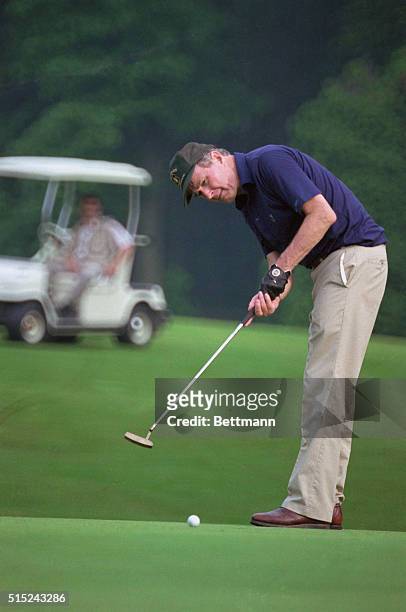Washington: President Bush watches the ball after his putt on the 18th hole during 18 holes of golf with Australian Prime Minister Robert Hawke at...