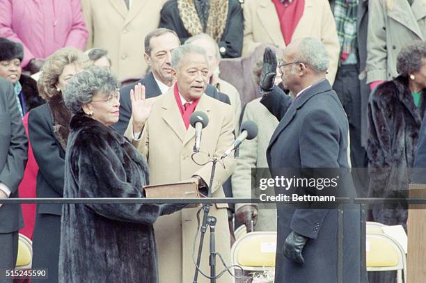 New York, NY- David Dinkins is sworn in as the first black mayor of NYC by judge Fritz Alexander. Holding the bible is wife Joyce and Gov. Mario...