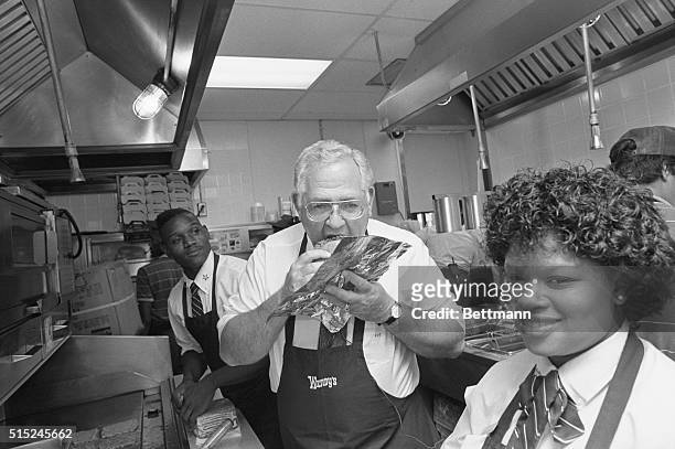 Atlanta, Georgia: Although he made this hamburger for a lunch customer, Wendy's founder Dave Thomas can't resist a quick snack in the kitchen of a...