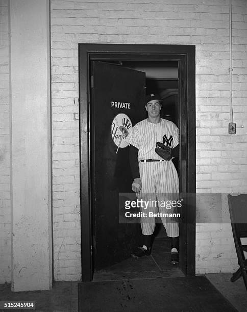 Back in his Yankee uniform for the first time since April 11, slugger Joe DiMaggio strides through the clubhouse door on his way to pre-game batting...