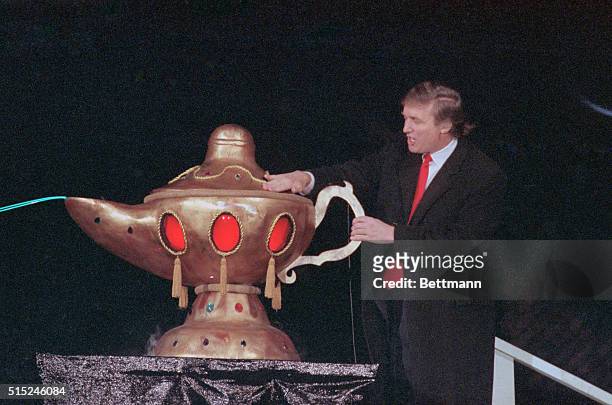 Atlantic City, N.J.: Donald Trump reaches over and rubs a huge Aladdin's Lamp during opening ceremonies for this Taj Mahal Casino. Trump has billed...