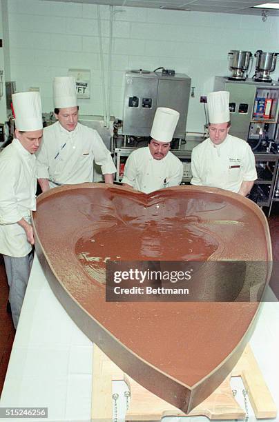 Chicago: Pastry Chef Ed Schultz , Jesus Pardino and Executive Chef Wolfgang Wildoer pour chocolate into heart frame measuring 7 feet tall and 5...