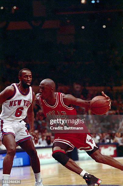 Chicago Bulls' Michael Jordan drives past the New York Knicks Trent Tucker during the second half of the Bulls' 103-94 win to sweep their opening...