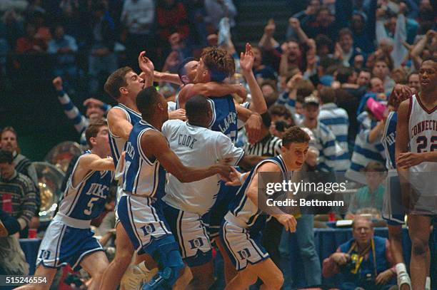 East Rutherford, New Jersey: Duke University teammates jump all over Christian Laettner who hit the winning basket in overtime to defeat the...