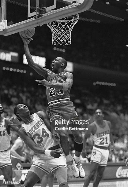 Chicago Bulls' Michael Jordan drives in for a reverse layup over Houston Rockets' Akeem Olajuwan in the first quarter of the Bulls-Rockets game, 2/1.