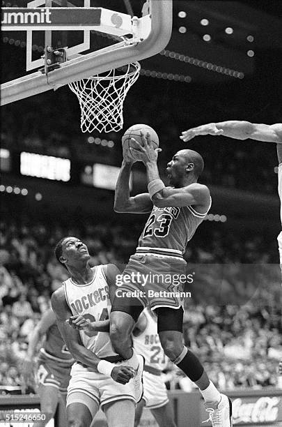 Chicago Bulls' Michael Jordan drives in for a reverse layup over Houston Rockets' Akeem Olajuwan in the first quarter of the Bulls-Rockets game, 2/1.