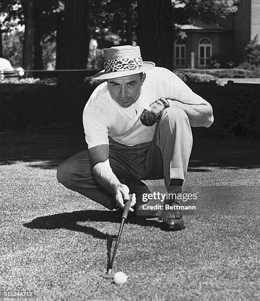 Sam Snead, recent winner of the PGA tournament at Richmond, Virginia, sights a putt on the Medinah Country Club green where he will play in the...