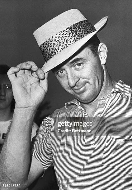 Portrait of golfer Sam Snead tipping his hat.