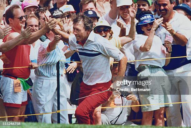 Medinah, Ill.: Hale Irwin slaps hands of fans as he runs along edge of the 18th green after sinking a 60 foot birdie to finish 8 under par in final...