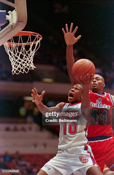 East Rutherford, N.J.: Mookie Blaylock of the New Jersey Nets drives the lane for two, but is fouled Harvey Grant of the Washington Bullets late in...