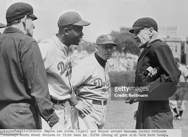 Umpire Lou Jorda and Dodger second baseman Jackie Robinson exchange words about decision at first base in fifth inning of game with cubs. Umpire...