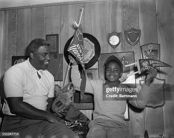 Jackie Robinson and 10 year old, Jackie Jr., appear happy over announcement of controversial star's retirement from baseball, as they pose in Robby's...