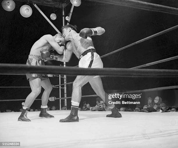 Action Shots on Zale-Cerdan Fight. Middleweight Marcel Cerdan connecting with a body blow to Tony Zale's stomach.