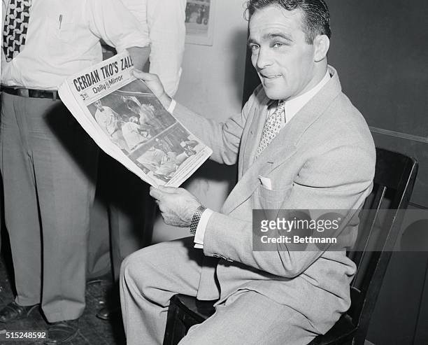 New York: Marcel Cerdan Has 1st Conference Since Being Champ At 1630 Broadway. Photo shows Marcel Cerdan looking at a fight pix with Zale pushing his...