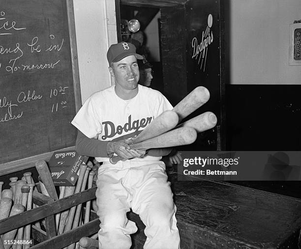 Brooklyn, New York: Noble Job By Duke. Dodgers' Snider, who homered in 6th and 8th for Brooks' only runs, happily eyes his "artillery" in locker...