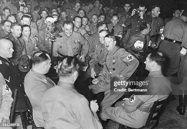 Martin Bormann, , Hitler's deputy, is shown in a 1938 beer cellar scene with Adolph Hitler and Rudolf Hess, .