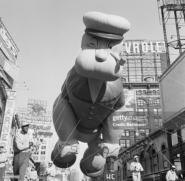 New York: Thanksgiving Day - Macy's Parade. 'Here comes Popeye. The pipe-puffing sailor man, high-strung and swaying in a brisk breeze, floats over...