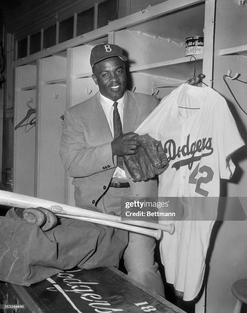 Jackie Robinson packing his baseball gear in the Dodger locker room ...