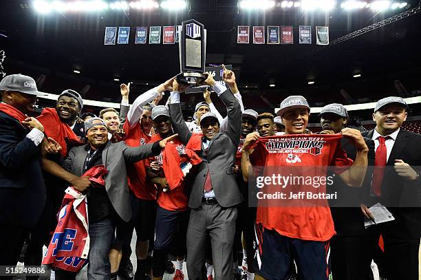 Head coach Rodney Terry of the Fresno State Bulldogs celebrates with players by hoisting the Mountain West Conference championship trophy with...
