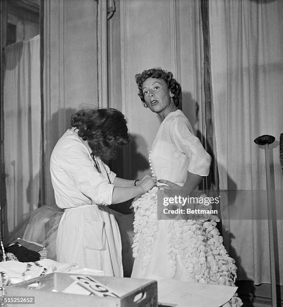 This photo shows a dressmaker and model at the Maison Schiaparelli at 21 Place Vendome.