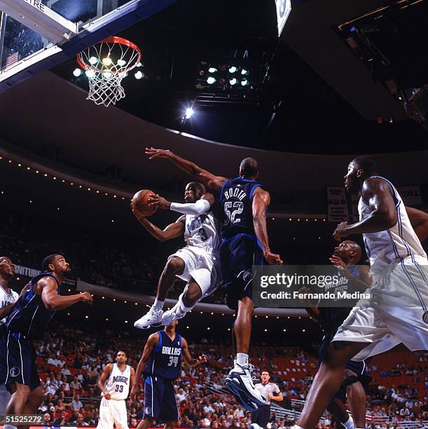 Steve Francis the Orlando Magic attempts a shot past Calvin Booth of the Dallas Mavericks during the game at the TD Waterhouse Center on October 17,...