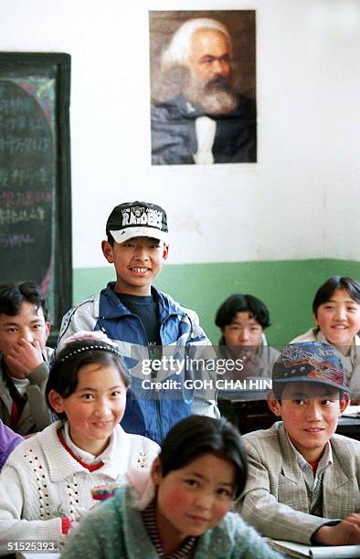 Tibetan boy answers a question during a lesson on socialism in the Lhasa Middle school 26 May under a portrait of Karl Marx. China, which has...