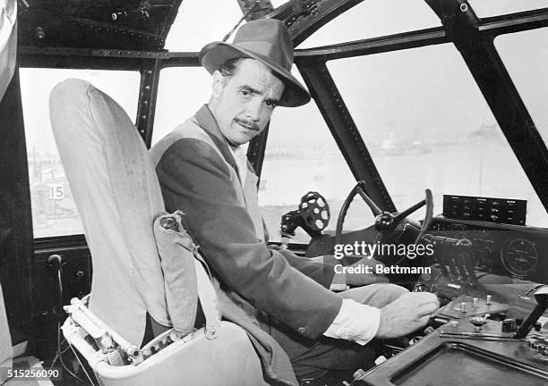 Howard Hughes at controls of the giant Hughes flying boat at its mooring at Terminal Island. The big flying boat is nearly ready for its taxi tests...