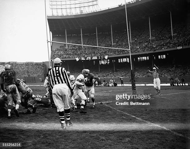 Cleveland Browns quarterback Otto Graham goes over for a first-quarter touchdown despite a desperate defensive stand by the Detroit Lions in the...